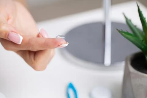 Solving vision problems, close up of woman holding contact lens 스톡 사진