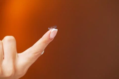 Solving vision problems, close up of woman holding contact lens 写真素材