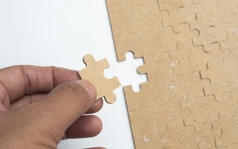 Solving white puzzle on light grey background, top view Stock Photos