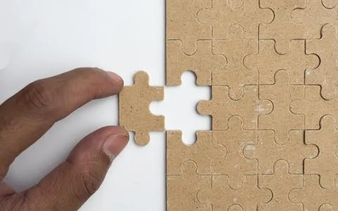 Solving white puzzle on light grey background, top view Stock Photos