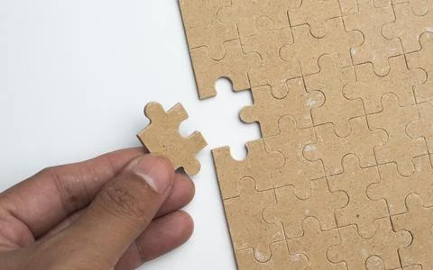 Solving white puzzle on light grey background, top view Stock Photos