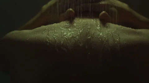 In a somber atmosphere, a man stands under a warm morning shower, letting th Stock Footage 255288978