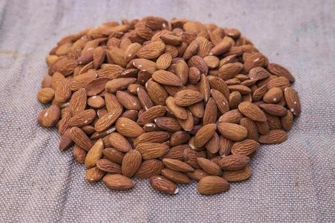 Some almonds on the brown Jute fiber fabric Stock Photos