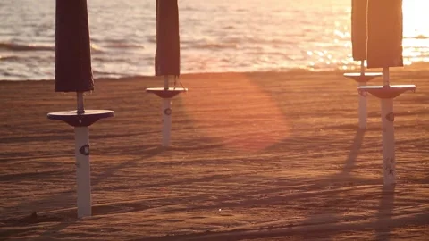 Some beach umbrellas in the beach without people at the sunlight Stock Footage 150349665