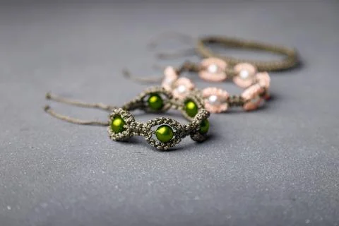 Some beaded bracelets from macrame yarn on grey background. Soft focused shot Stock Photos