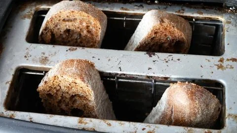 Some beautiful slices of bread are toasted in an old toaster close-up Stock Photos