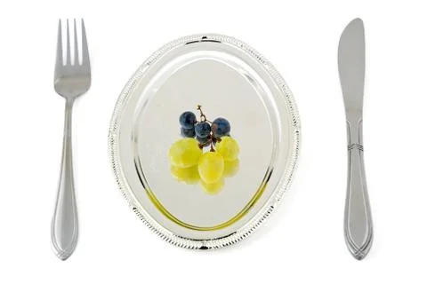 	Some berries of a grape lay on a silver plate Stock Photos