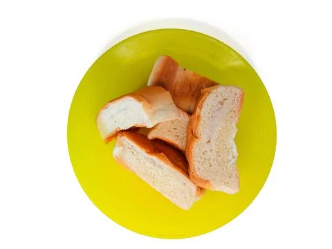 Some bread on a yellow plastic plate, isolated on a white background Stock Photos