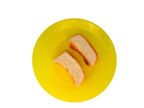 Some bread on a yellow plastic plate, isolated on a white background Stock Photos