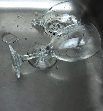 Some broken glass goblets inside a sink, concept of fragility Stock Photos