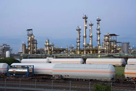 Some cargo trains in front of a chemical plant. Stock Photos