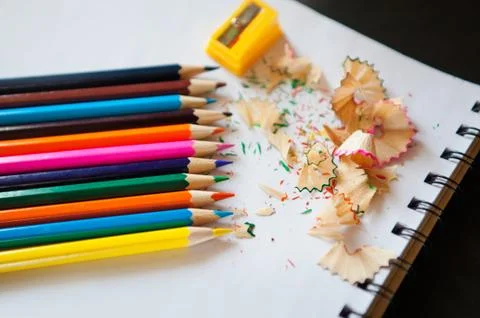 Some colored pencils of different colors and a pencil sharpener Stock Photos
