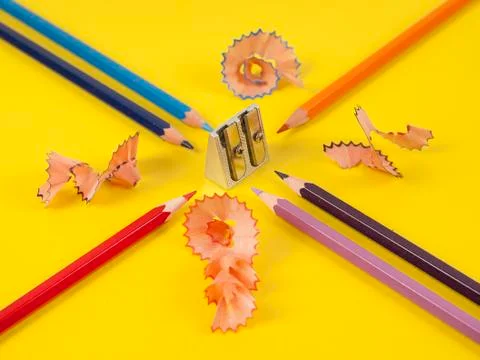 Some colored pencils of different colors and a pencil sharpener and pencil sh Stock Photos