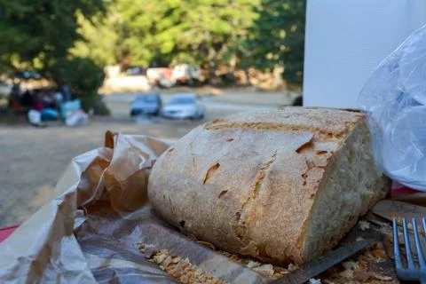 Some cut bread, a steel fork and some plastic cups Stock Photos