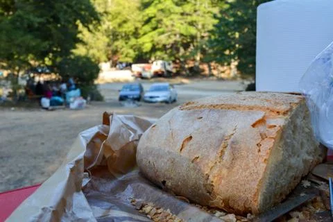 Some cut bread, a steel fork and some plastic cups Stock Photos