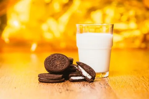 Some dark glass of milk and cookies on a blurred background Stock Photos