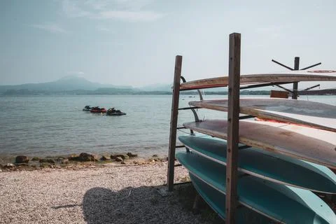 Some different surfboards are stacked on top of each other on the shore of a Stock Photos