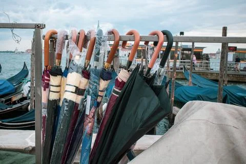 Some different umbrellas hang side by side on a stand 写真素材