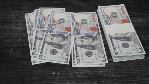 Some dollar bills scattered on the black table Stock Footage 309898062