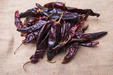 Some Dry Pepper or red chili on the brown jute fiber fabric Stock Photos