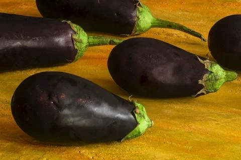 Some eggplants on a yellow table Foto stock