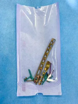 Some explanted titanium screws and titanium plates in different colors and si Stock Photos