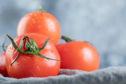Some of fresh tomatoes on a gray tablecloth Stock Photos