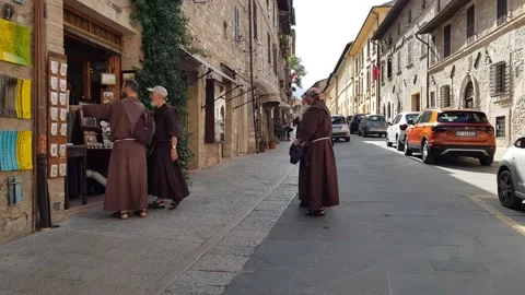 Some friars in front of a shop in Assisi, Umbria Stock Footage 202601320