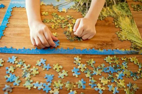 Some hands working on a puzzle Stock Photos