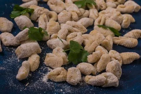 Some made gnocchi with basil on a table Stock Photos