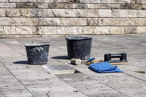 Some Masonry Tools and Buckets on Stone Pavement During Outdoor Tile Repair a Stock Photos