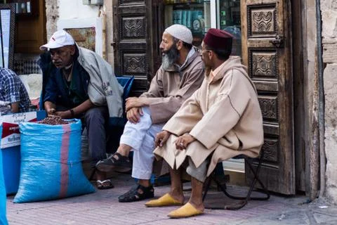 Some old men having a chat in front of the door of a shop in the market Stock Photos