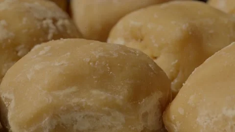 Some one picking (gud) Organic hand made jaggery in plant india Stock Footage 224018577