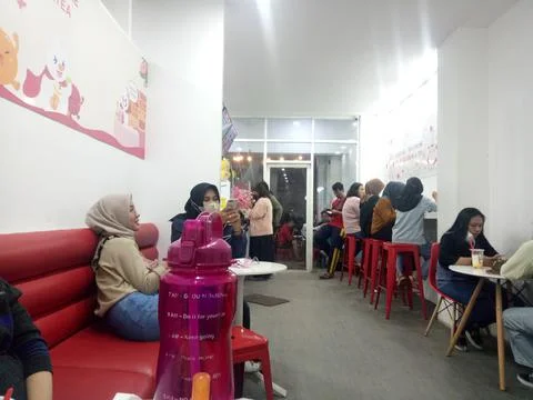 Some people are queuing to buy drinks at a cafe called mixue at night in the  Stock Photos