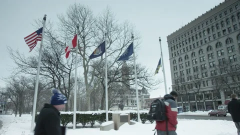 Some People Walk By Some Flags in Buffalo Stock Footage 171816797