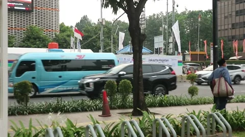 Some people walking on the sidewalk on the side of the highway Stock Footage 211650094