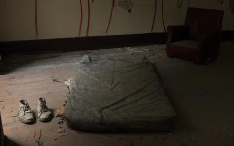 Some poor person's bed in an abandoned and dilapidated building Foto stock