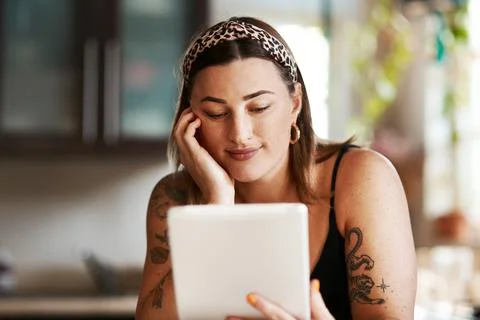 Some posts just speak to you. a young woman using a digital tablet in the Stock Photos