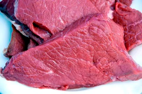 Some raw beef fillets on a plate. Close up macro. Selective focus. Stock Photos