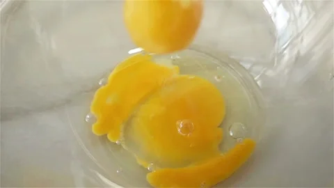 Some Raw Eggs Falling on Glass Bowl in Slow Motion Stock Footage 129261452