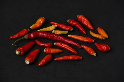 Some red chillies on the dark table Stock Photos