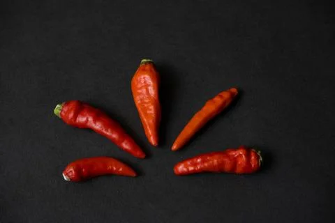 Some red chillies on the dark table Stock Photos