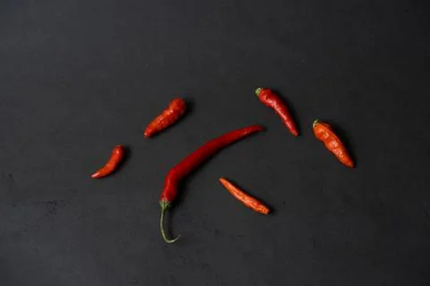 Some red chillies on the dark table Stock Photos