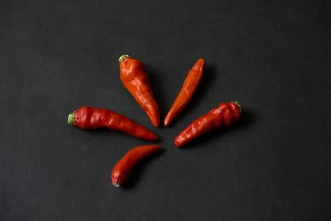 Some red chillies on the dark table Stock Photos