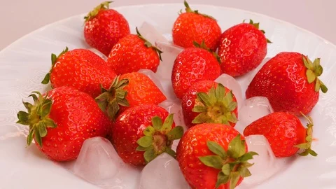 Some red ripe strawberries with ice cubes on a rotating plate. Stock Footage 101583360