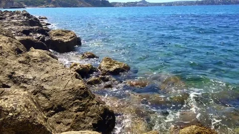 Some rocks at bay with clean blue water Stock Footage 71770713