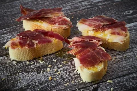 Some slices of bread with Iberian ham and olive oil Stock Photos