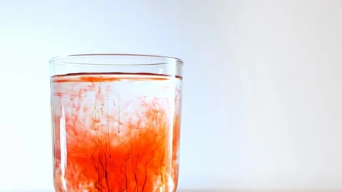 Some small particles red green colors of chemical substance fall into glass 動画素材 116050995