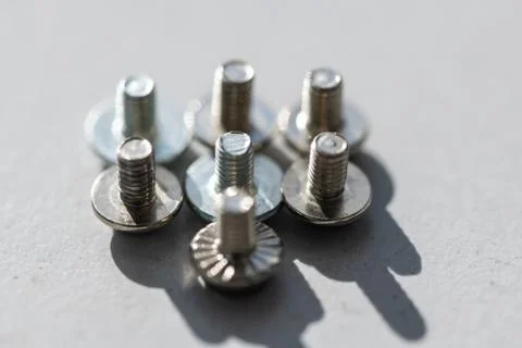 Some small  screws lined up in the light with gray background Stock Photos