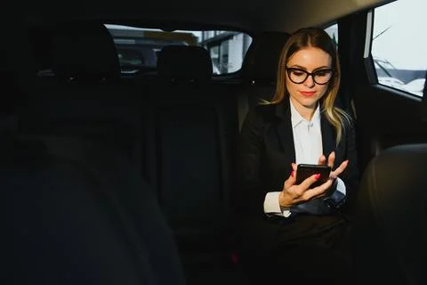 Some sort of interesting information. Smart businesswoman sits at backseat .. Stock Photos